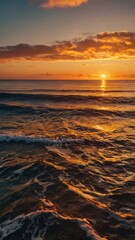Naklejka premium Golden sunset over tranquil ocean waves reflecting warm colors in the sky near the shoreline