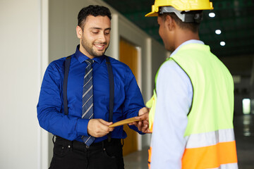 boss or manager giving money to worker for jobs in the factory