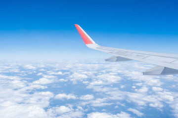 Airplane wing, Clouds and blue sky has seen through the window of an aircraft view
