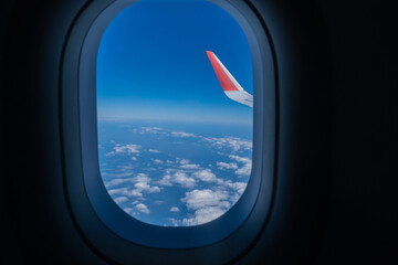 Airplane wing, Clouds and blue sky has seen through the window of an aircraft view