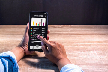 Woman using a smartphone app to calculate the monthly bills or household expenses