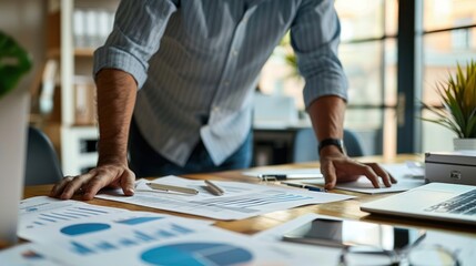 A man reviewing and organizing documents and notes at a desk.