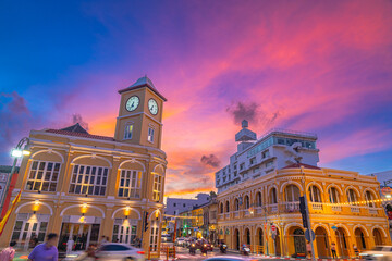 Fototapeta premium Pink cloud in blue sky above The classic building in Phuket old town. Scene of romantic beautiful sky sunset with slow moving cloud in the sky background. The clock tower is a landmark of Phuket.