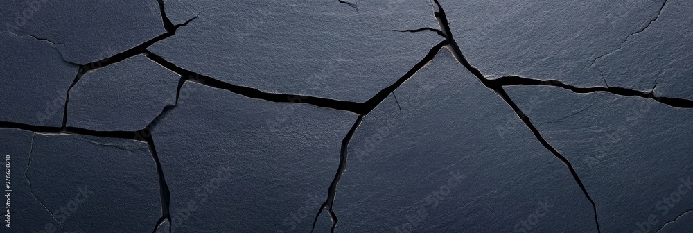 Poster a dark textured surface with a rough cracked appearance. the cracks are deep and jagged, creating a 
