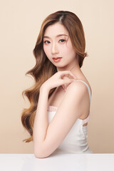 Fototapeta premium Beautiful young asian woman with clean fresh skin on beige background, Face care, Facial treatment, Cosmetology, beauty and spa, Asian women portrait.
