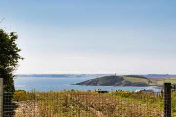 Scenic Coastal View with Lighthouse and Hills in Cornwall, UK