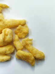 yellow crunchy corn chips with a sweet and savory taste on a white background.