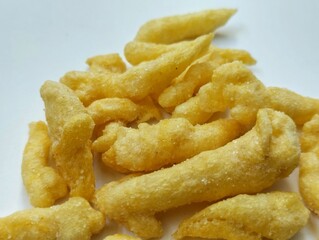 yellow crunchy corn chips with a sweet and savory taste on a white background.