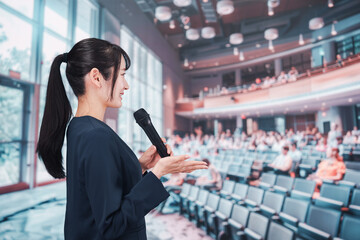ホールで司会をする若い女性
