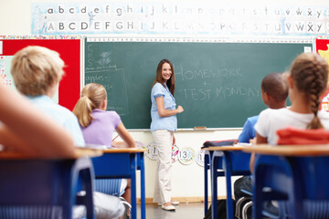 Blackboard, teaching and woman in kids classroom for learning, growth and child development. Smile,...