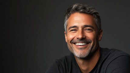 Fototapeta premium A man with graying hair smiles at the camera.