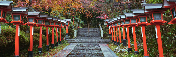 Panorama of Traditional lamp posts beside the stairs in the Kurama Dera Temple in  Kyoto, Japan.