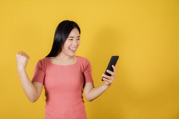 Happy Asian woman raise hands glad excited cheerful and holding mobile phone or smartphone