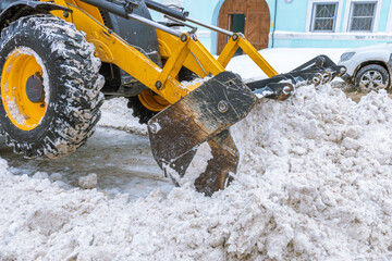 A snow plow is clearing snow from the road