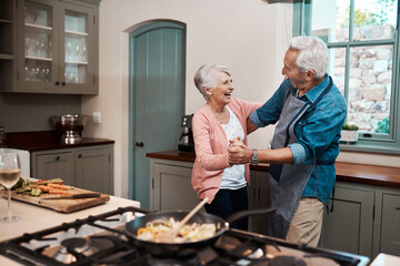 Dancing, happy and senior couple in kitchen cooking healthy dinner together with bonding. Love, retirement and elderly man and woman groove to music, radio or playlist for preparing supper in home.