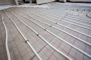 View on thin white tubes bended in complex curve of new brass, distribution system manifold mounted...