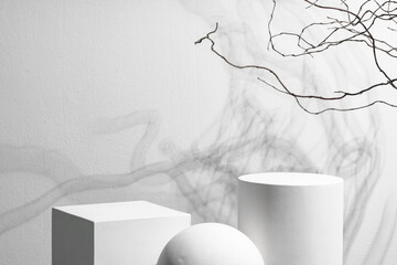 Abstract composition featuring three white geometric shapes in a minimalist interior setting