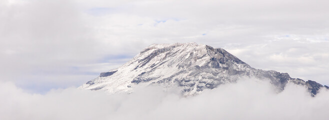 Obraz premium Paisaje de la cima del Iztaccíhuatl (Mujer Dormida) con nieve rodeado por nubes 