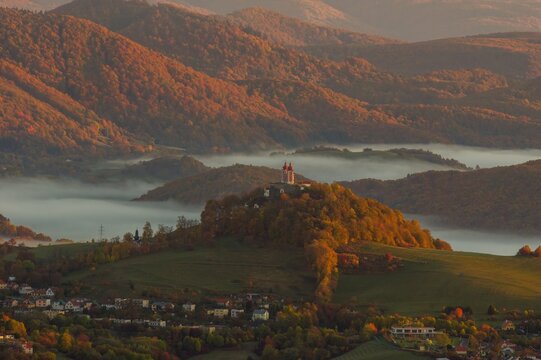 Beautiful autumn landscape of a church on a hill in Slovakia. Idyllic scenery from a bird's eye view of the picturesque town of Banska Stiavnica