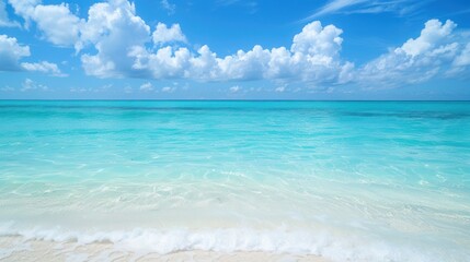 Obraz premium Turquoise ocean waves and white sandy beach under a blue sky. Tropical paradise photography for design and print.