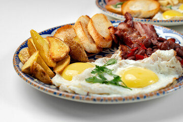Two plates of a hearty breakfast served on decorative bowls