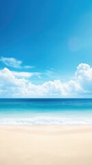 Obraz premium A serene beach scene with golden sand, vibrant blue sea, and a clear sky dotted with fluffy clouds, perfect for relaxation.