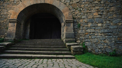 Stone stairway leading up to an old wooden door in a medieval castle