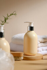 The image features a yellow bottle with a pump dispenser, surrounded by white towels, a wooden brush, and a rosemary sprig, ideal for spa or beauty care product advertising.