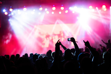 Crowd at concert and colorful stage lights.