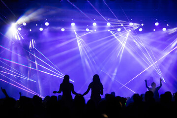 Crowd at concert and colorful stage lights.