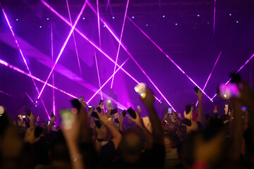 Crowd at concert and colorful stage lights.