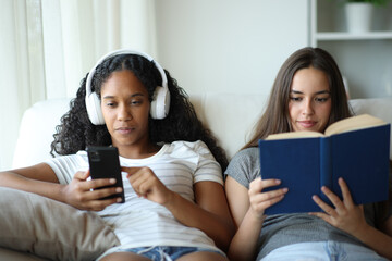 Interracial roommates listening music and reading book