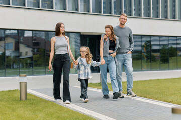 Fototapeta premium Portrait of a happy family with children walking around the city on a weekend