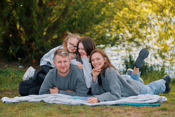 Fototapeta premium Happy childhood, two daughters spend time with their parents on a picnic in the park