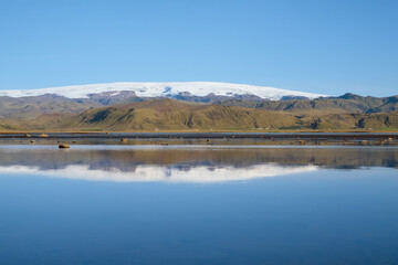 Lake reflecting the snow-capped mountains of Iceland. Island of Iceland. Landscape photography.