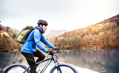 Fototapeta premium Active man on bike in the middle of beautiful nature, early autumn morning. Concept of healthy lifestyle.