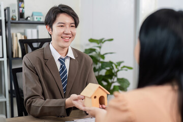 Fototapeta premium Real Estate Agent Facilitating Property Sale Discussion with Client for Home Ownership Goals