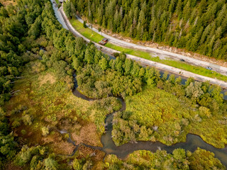 Aerial view of mountain road between forest and river. Ecosystem, ecology, healthy environment, road trip