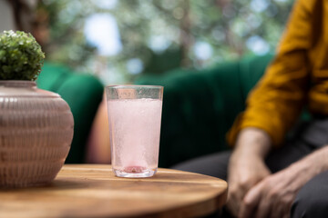 Elderly people drinking effervescent vitamins dissolved in water glasses, using for recovery and hydration. Senior couple taking supplements for wellness and longevity, health care. Close up.