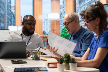 Senior couple in a modern office discussing retirement plans with a financial advisor. Clients consulting a broker to ensure a secure pension with life savings and insurance, advisory meeting.