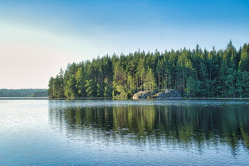 Bay in a lake in Sweden with blue water and trees on the shore. Scandinavian nature
