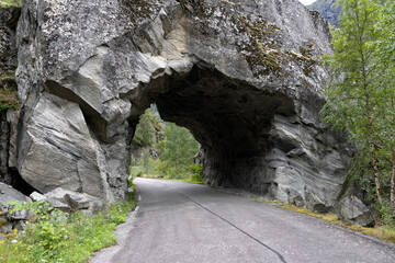 Tunnel on a disused stretch of road in the Norwegian mountain landscape. The road was closed due to a high risk of landslides and is located in extreme but beautiful surroundings