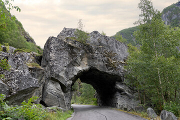 Tunnel on a disused stretch of road in the Norwegian mountain landscape. The road was closed due to a high risk of landslides and is located in extreme but beautiful surroundings