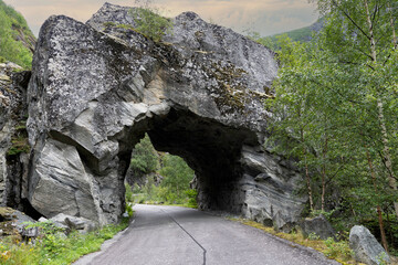 Tunnel on a disused stretch of road in the Norwegian mountain landscape. The road was closed due to a high risk of landslides and is located in extreme but beautiful surroundings