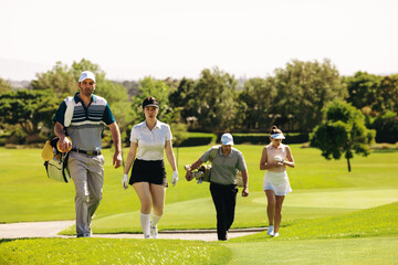 Fototapeta premium Group of golfers with golf bags walking on a golf course during a match