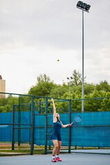 Fototapeta premium Young woman in motion on the tennis court