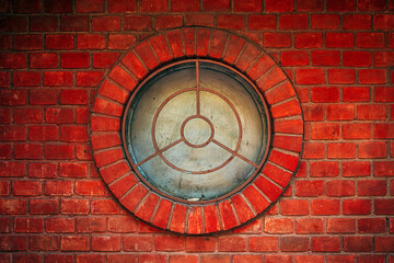 Round window, circular shaped window on a brick wall