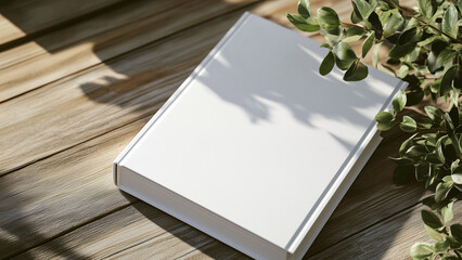 Fototapeta premium Minimalist Still Life: White Soft Cover Book with Plant, Bird's Eye View