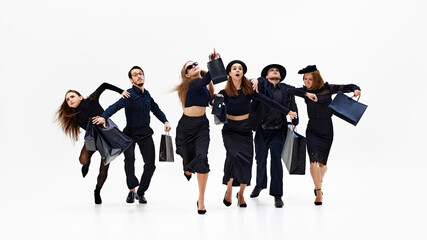 Group in mid-motion, with some pointing forward as if heading toward something important against white studio background. Concept of shopping, Black Friday, fashion and style, sale season. Ad
