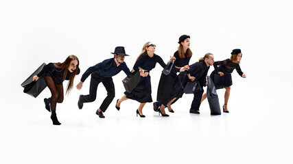 Six shoppers launching into race, their all-black fashion adding sense of urgency and sophistication as they leap forward with shopping bags. Concept of shopping, Black Friday, fashion and style. Ad